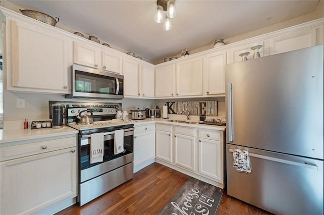 57 Jonathan Rd, Riverdale, GA 30274 - kitchen featuring appliances with stainless steel finishes, a sink, dark wood finished floors, and white cabinets