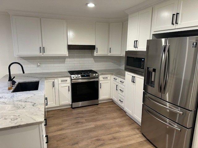 1360 Bethany Ct, Alpharetta, GA 30004 - kitchen featuring appliances with stainless steel finishes, white cabinets, light stone countertops, decorative backsplash, and recessed lighting