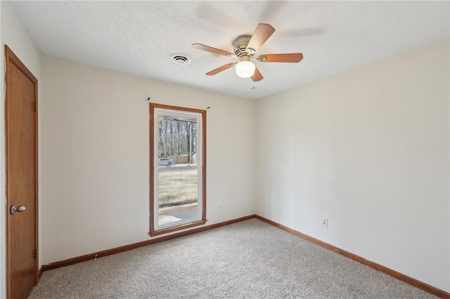 carpeted spare room with visible vents, baseboards, a textured ceiling, and ceiling fan