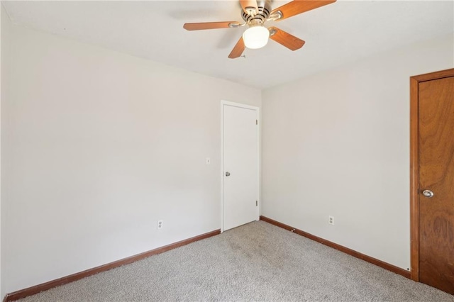 spare room with carpet, baseboards, and ceiling fan