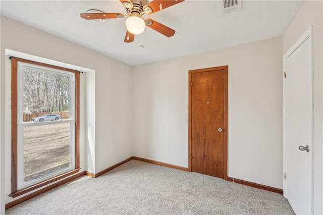 spare room with visible vents, baseboards, carpet, and a ceiling fan