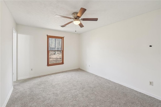 empty room featuring a ceiling fan, carpet, baseboards, and a textured ceiling