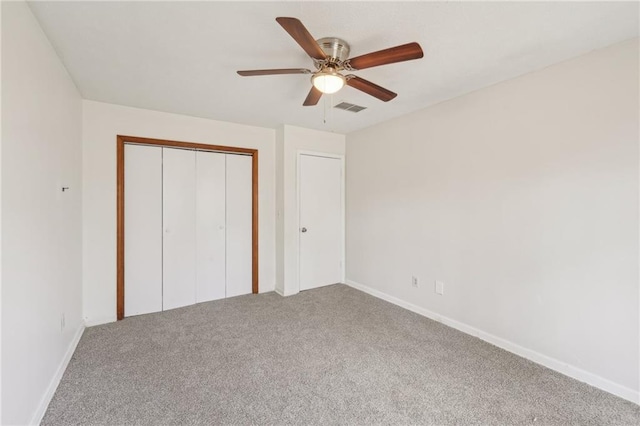 unfurnished bedroom with visible vents, a ceiling fan, a closet, carpet, and baseboards