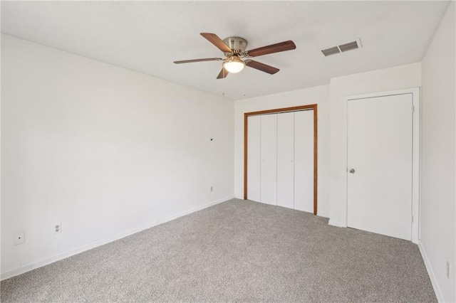 unfurnished bedroom featuring visible vents, baseboards, carpet floors, a closet, and a ceiling fan