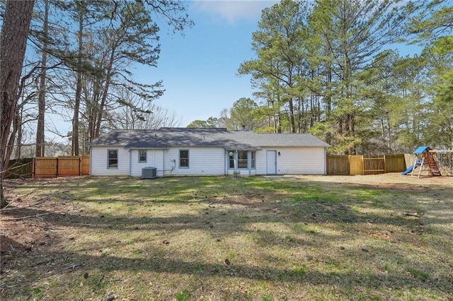 view of front of home featuring a fenced backyard, a front yard, a playground, and central AC