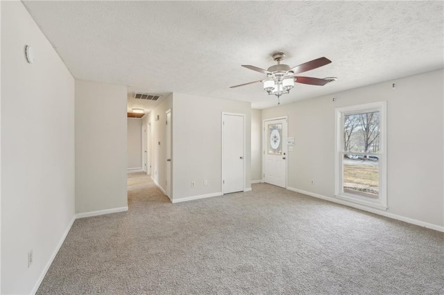 unfurnished room featuring ceiling fan, carpet, visible vents, and baseboards