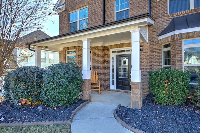 property entrance featuring brick siding and a porch