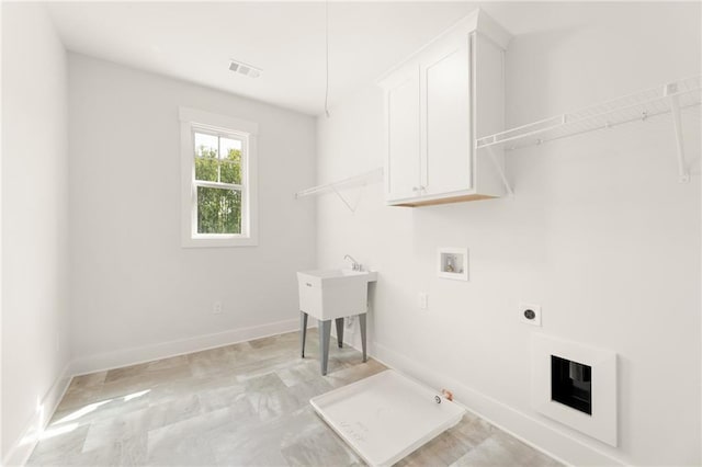 laundry room featuring hookup for a washing machine, cabinets, gas dryer hookup, and electric dryer hookup