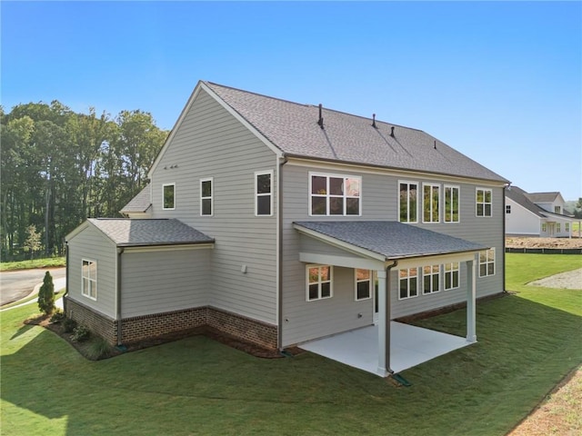 back of property with a yard and a patio