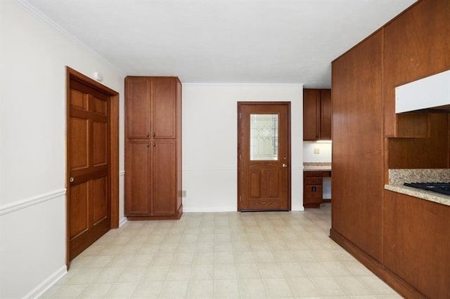 hallway featuring ornamental molding, baseboards, and light floors