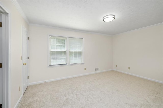 empty room featuring light carpet, baseboards, and crown molding