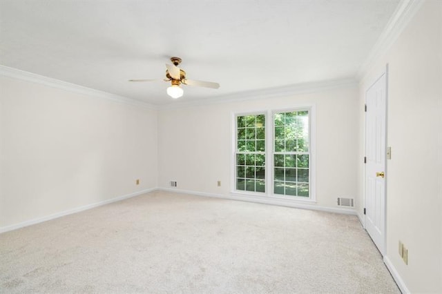 empty room featuring crown molding, baseboards, and light colored carpet