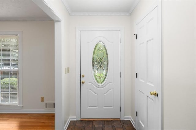 entrance foyer with dark wood-type flooring, visible vents, ornamental molding, and baseboards