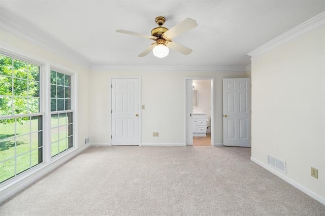 interior space featuring baseboards, ornamental molding, visible vents, and light colored carpet