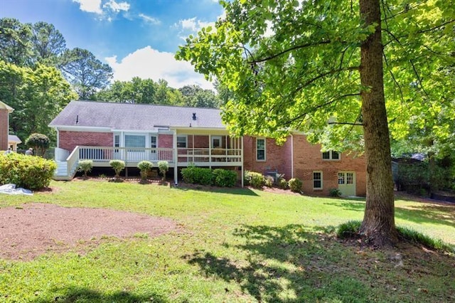 back of house with brick siding, a lawn, and a wooden deck