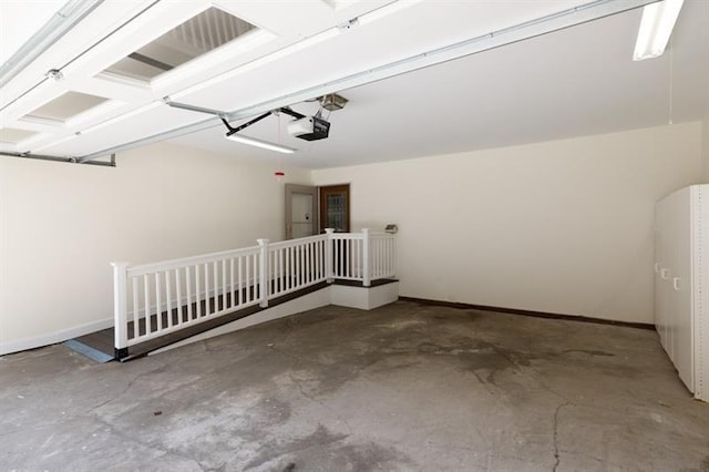 interior space with a garage door opener and baseboards