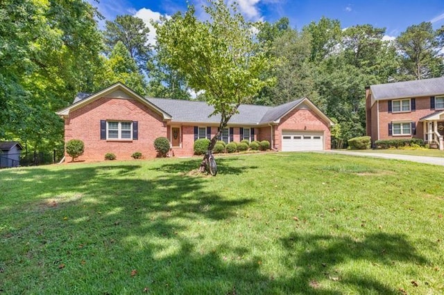 view of front of home with a garage, brick siding, driveway, and a front lawn