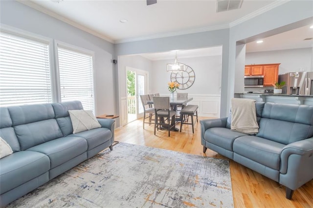 living room with crown molding and light wood-type flooring