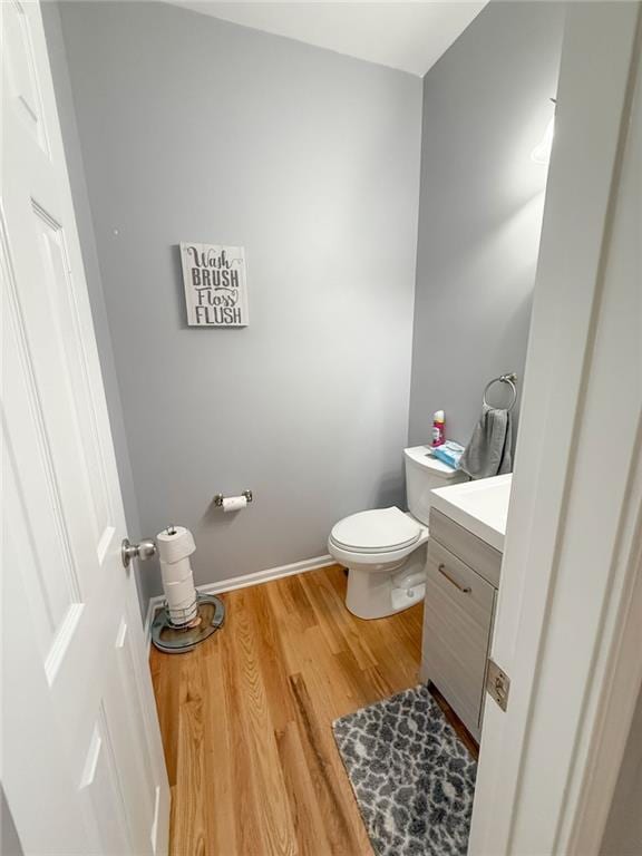 bathroom with toilet, hardwood / wood-style flooring, and vanity