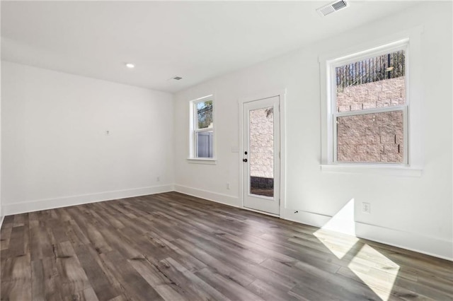 unfurnished room with visible vents, recessed lighting, dark wood-type flooring, and baseboards