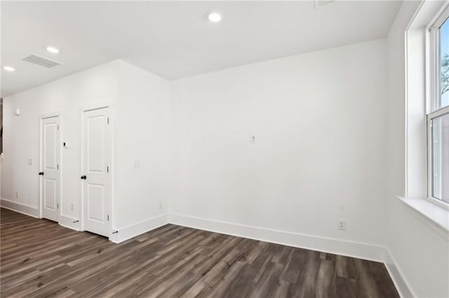 unfurnished room featuring recessed lighting, visible vents, baseboards, and dark wood-type flooring