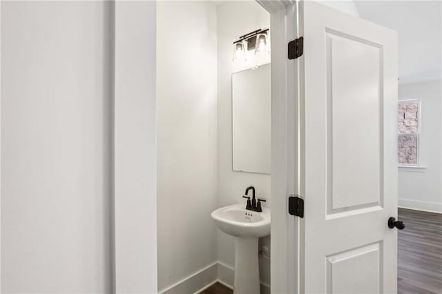 bathroom featuring wood finished floors, baseboards, and a sink