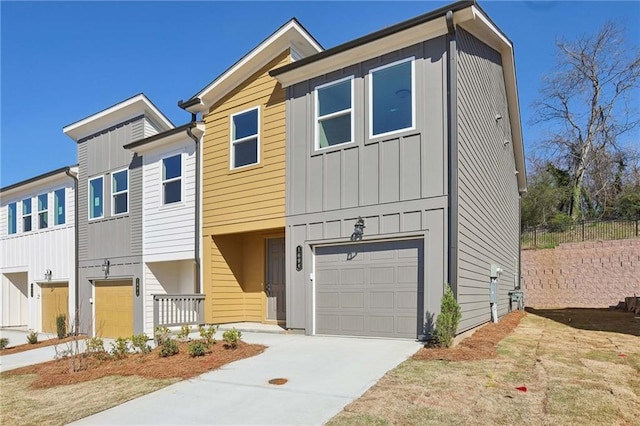 townhome / multi-family property featuring concrete driveway, a garage, fence, and board and batten siding