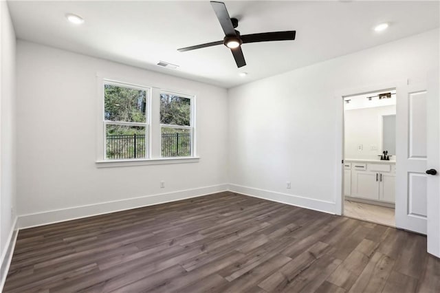 unfurnished bedroom featuring visible vents, baseboards, dark wood finished floors, recessed lighting, and ensuite bathroom