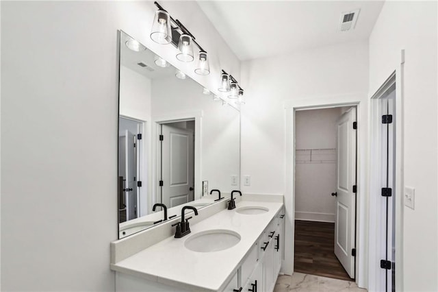 bathroom with double vanity, visible vents, and a sink