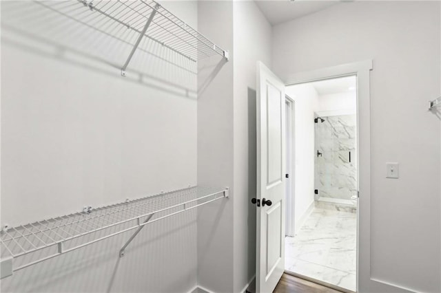 walk in closet with marble finish floor