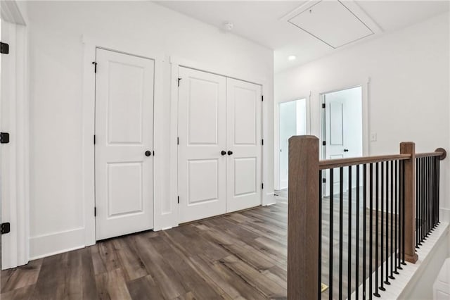 hall featuring an upstairs landing, dark wood-style floors, recessed lighting, baseboards, and attic access