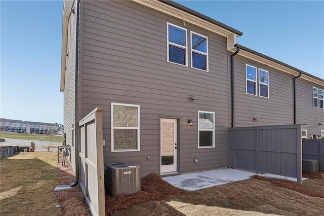 rear view of house with a patio area, central AC unit, and fence