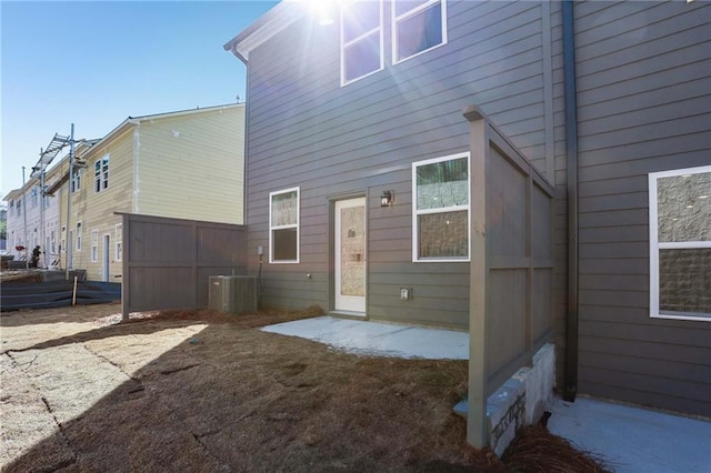 rear view of property featuring a patio, central air condition unit, and fence