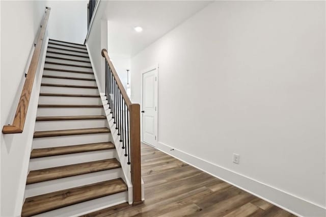 stairway with recessed lighting, baseboards, and wood finished floors