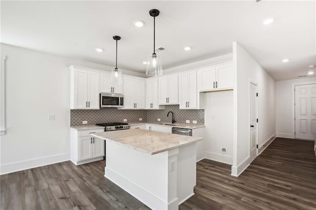 kitchen with dark wood-style floors, appliances with stainless steel finishes, white cabinetry, and a sink