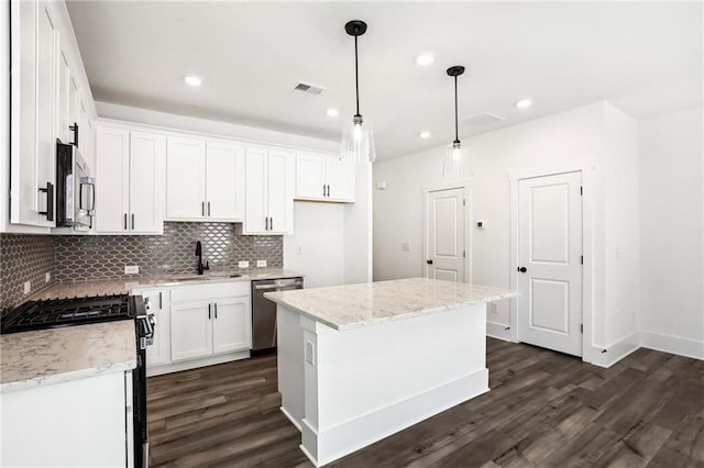 kitchen with a sink, stainless steel appliances, visible vents, and dark wood finished floors