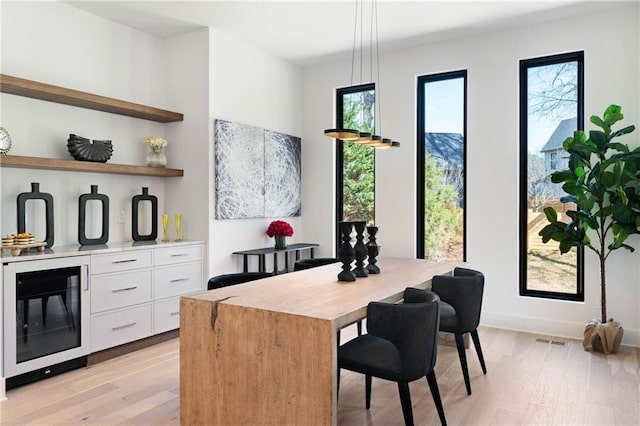 interior space with wine cooler and light hardwood / wood-style flooring