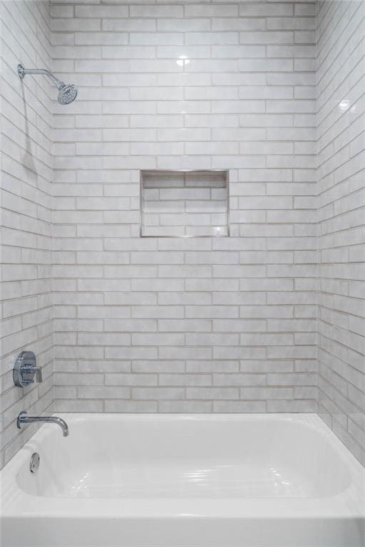 bathroom featuring tiled shower / bath