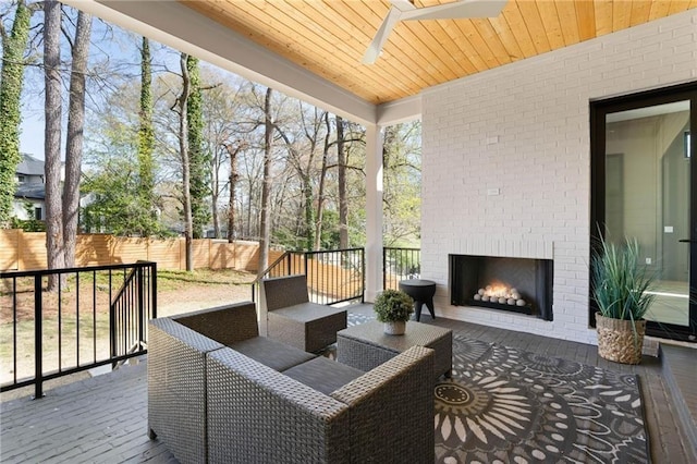 wooden deck with an outdoor brick fireplace