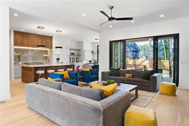 living room featuring ceiling fan and light hardwood / wood-style floors