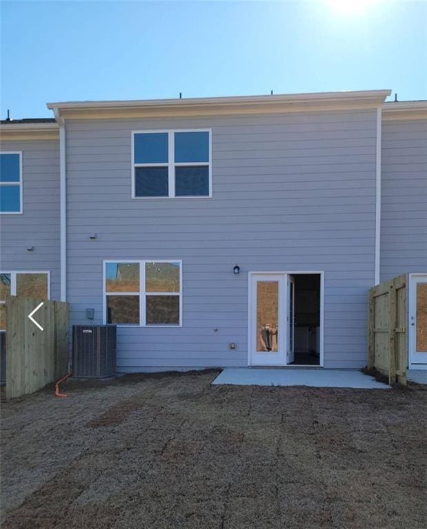 rear view of property with cooling unit and a patio