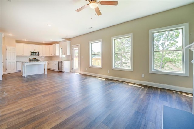 unfurnished living room featuring ceiling fan and dark hardwood / wood-style floors