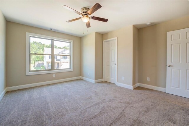 unfurnished bedroom with ceiling fan and light colored carpet