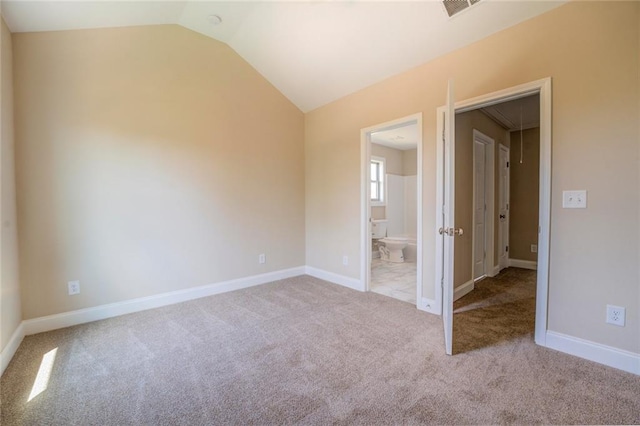 carpeted empty room with lofted ceiling