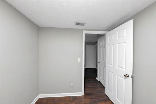 interior space featuring dark hardwood / wood-style floors and a textured ceiling