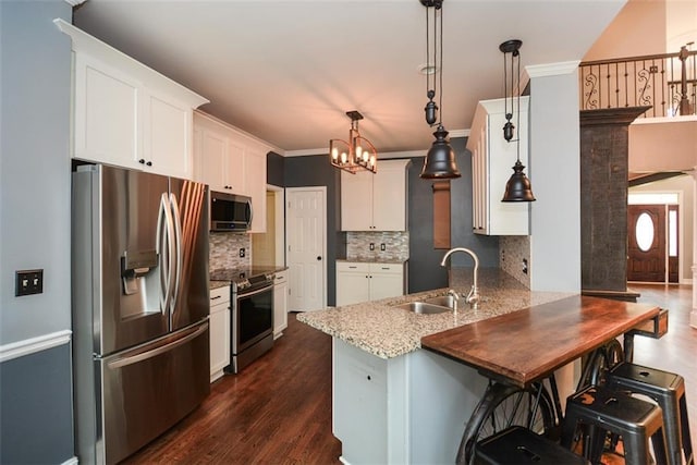 204 Maple Creek Chase, Woodstock, GA 30188 - kitchen featuring a notable chandelier, a sink, a peninsula, white cabinetry, and stainless steel appliances