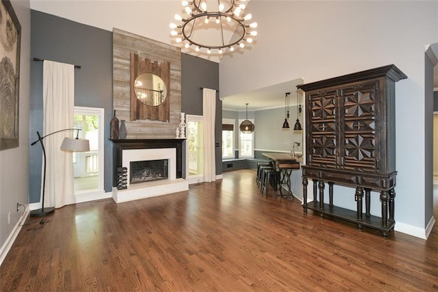204 Maple Creek Chase, Woodstock, GA 30188 - unfurnished living room with a fireplace, a notable chandelier, baseboards, and wood finished floors