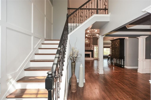 204 Maple Creek Chase, Woodstock, GA 30188 - staircase with a towering ceiling, a fireplace, decorative columns, a decorative wall, and wood finished floors