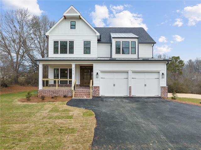 modern farmhouse style home featuring aphalt driveway, a shingled roof, covered porch, a front yard, and an attached garage