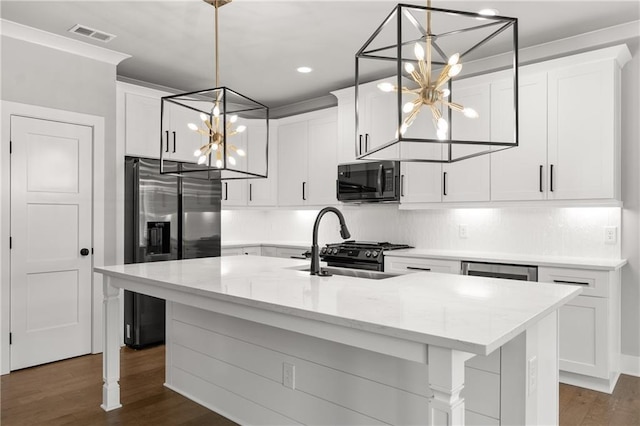 kitchen featuring refrigerator with ice dispenser, a chandelier, black microwave, and white cabinetry